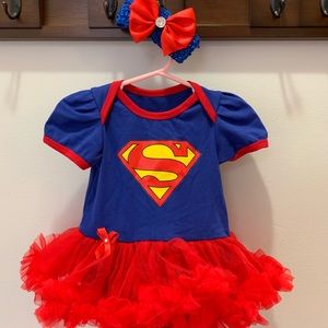 Supergirl ruffle onesie with matching headband.